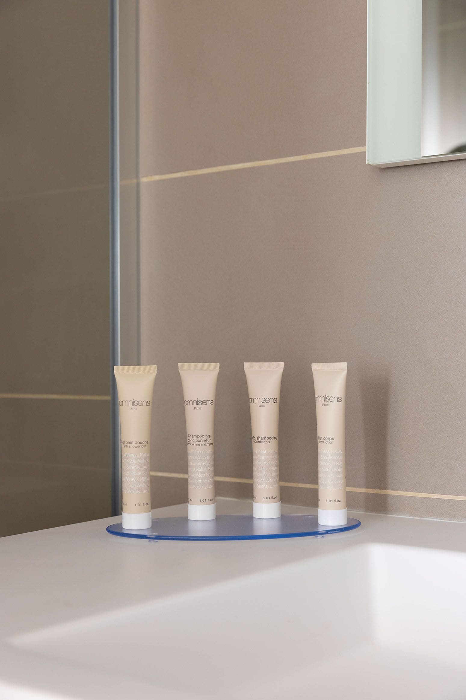 A bathroom with a white sink and three toiletries on a blue tray.