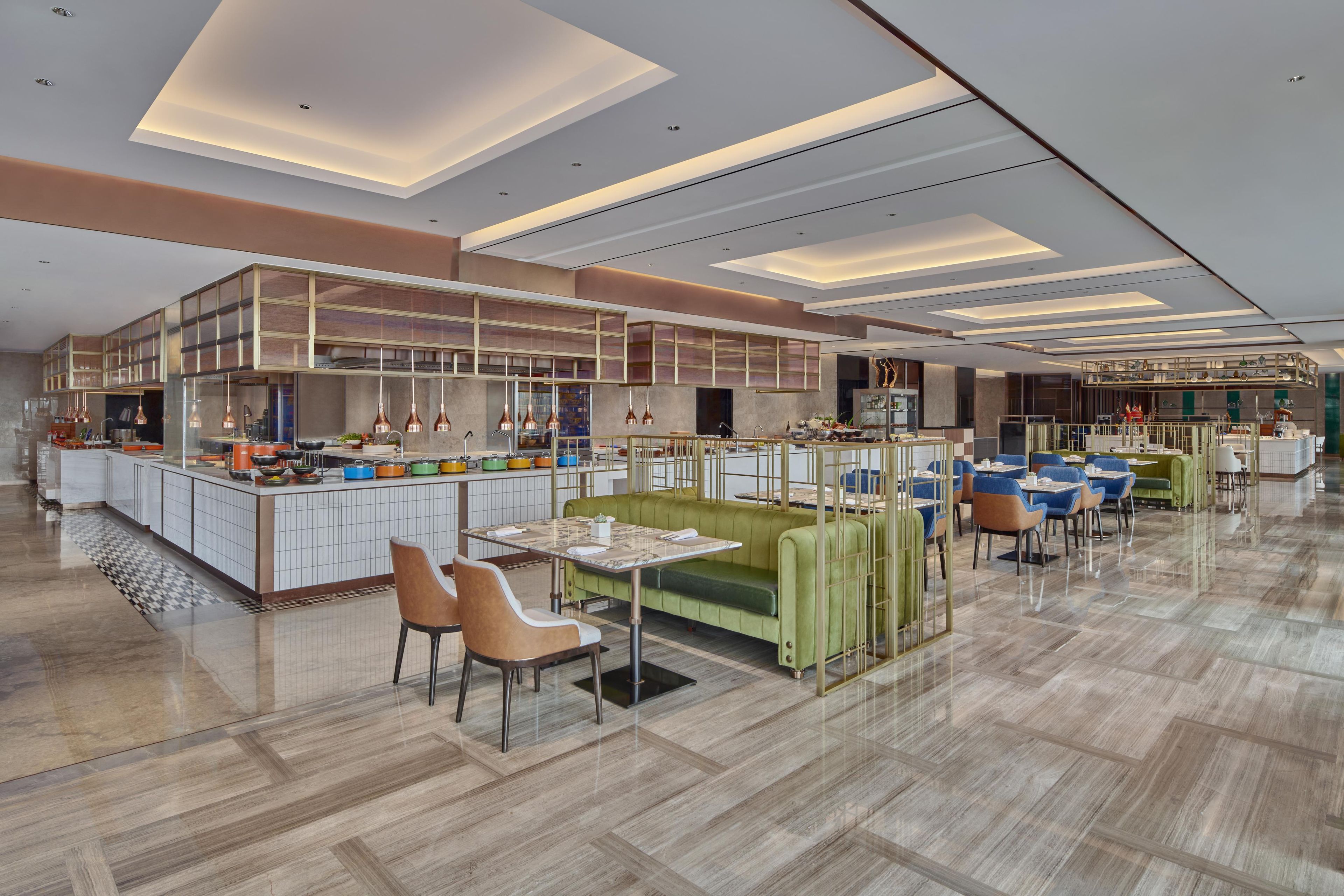 A modern restaurant with a central bar area, seating arrangements, and a polished floor.