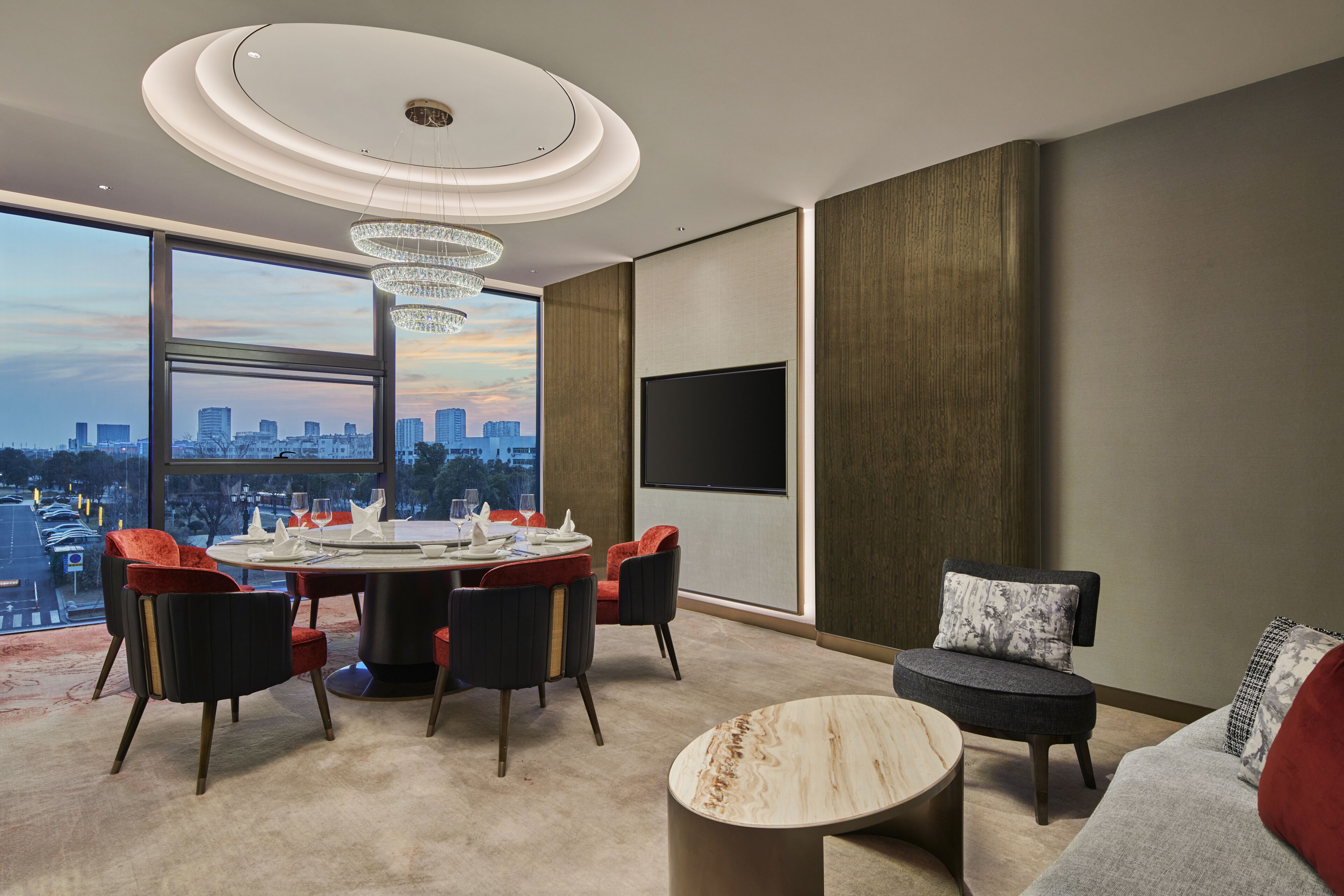 Una sala moderna con vistas a la ciudad, una mesa de comedor redonda y asientos cómodos.