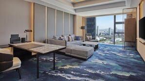 A modern hotel room with a large window, a sofa set, a dining table, and a TV. - Hilton Yancheng (Yancheng)