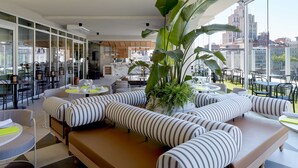 Uma área de estar moderna com um amplo sofá de canto, uma mesa de jantar e cadeiras.
