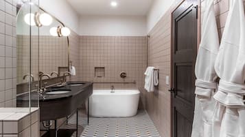 Un baño moderno con una bañera amplia, lavamanos dobles y una zona de ducha con mampara de vidrio.