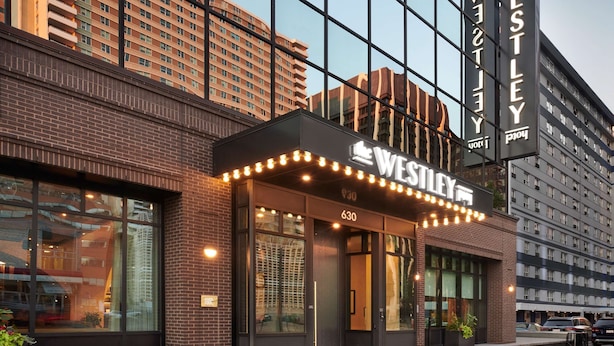 A modern hotel with a glass facade, a marquee sign, and a brick exterior. - The Westley Hotel - Tapestry Collection by Hilton (Calgary)