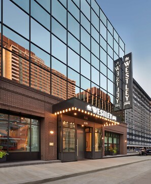 A modern hotel with a glass facade, a marquee sign, and a brick exterior. - The Westley Hotel - Tapestry Collection by Hilton (Calgary)