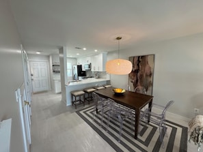 A modern kitchen with white cabinets, a central island, and a pendant light. - Completely remodeled beachfront condominium with swimming pool and beach access (Panama City Beach)