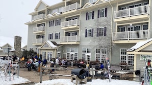 A multi-story hotel with balconies, outdoor seating, and a sign for 'Powder Waffle Cafe'.