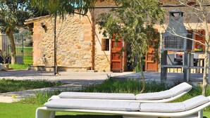 A stone building with a rustic appearance, a small window, and a wooden door. - Es Camp Pla 087 cosy finca with private pool, terrace, garden, barbecue and air-conditioning (Sineu)