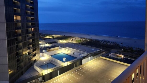 Un hotel con piscina en la azotea y vista al mar.