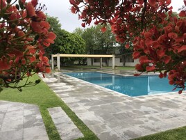 Una piscina al aire libre, sillones reclinables de piscina