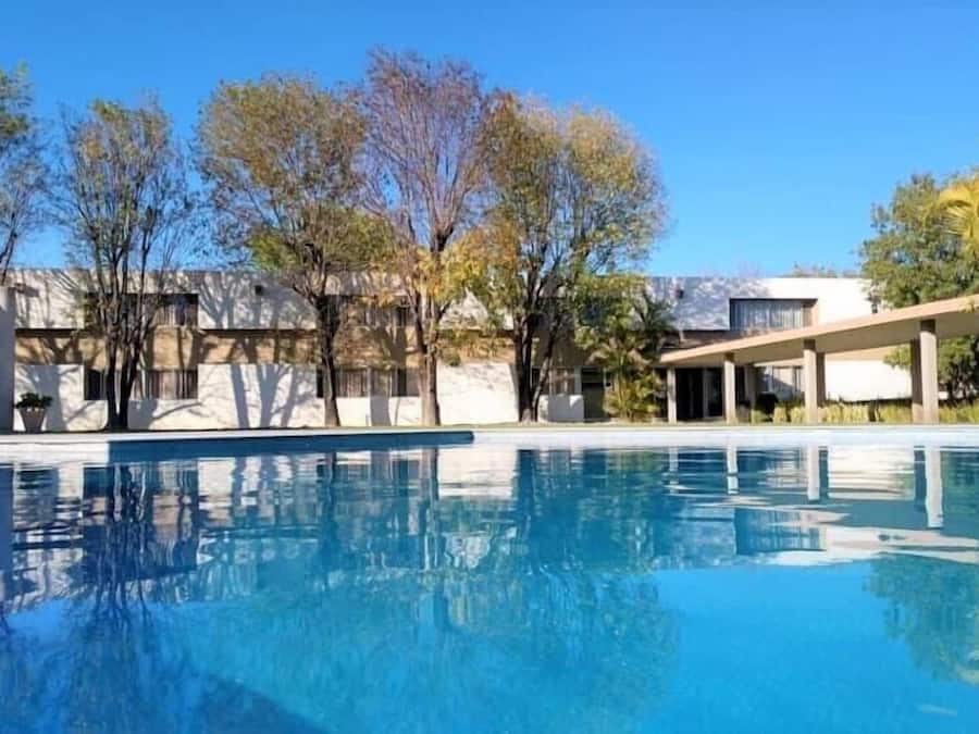 Una piscina al aire libre, sillones reclinables de piscina