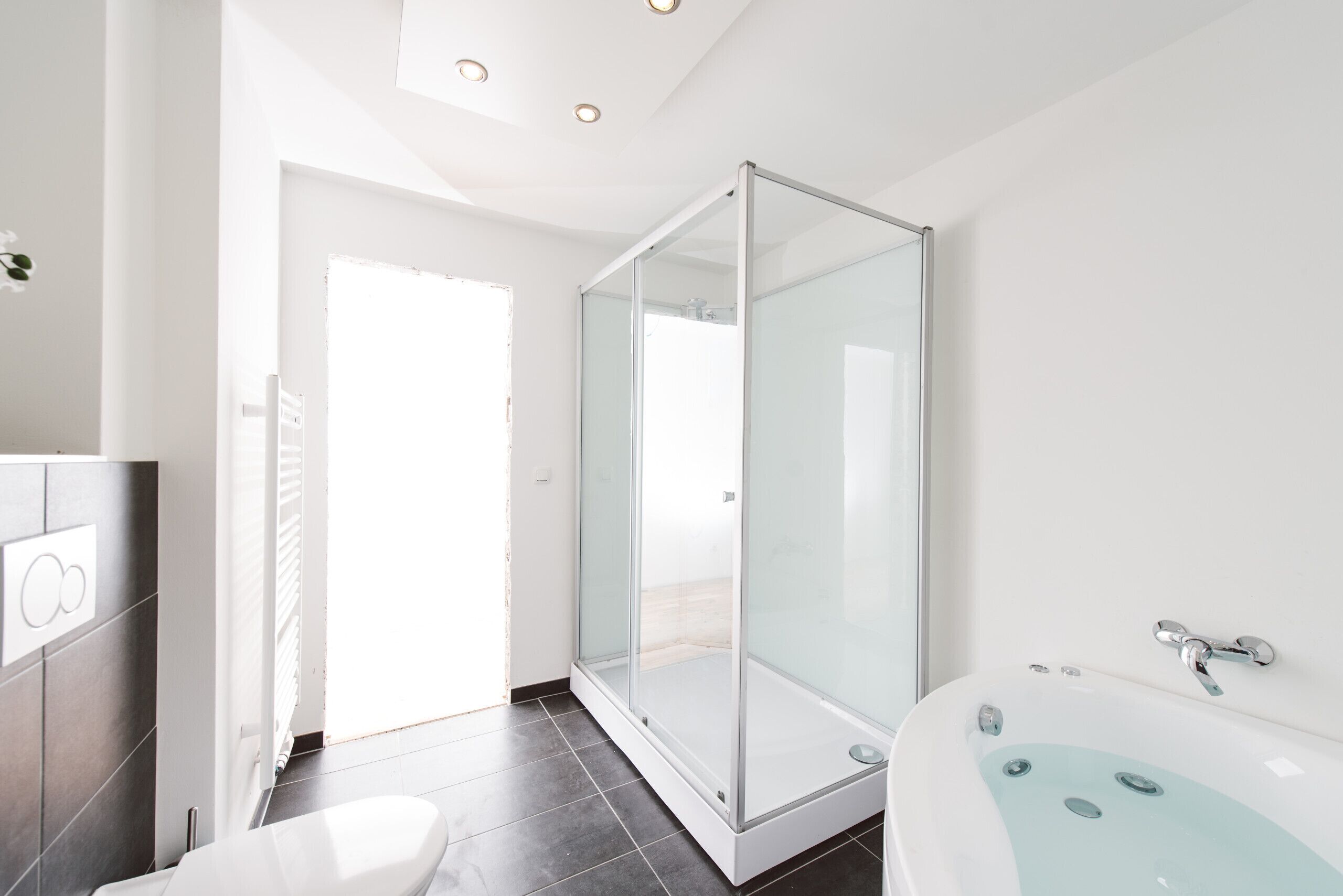 Une salle de bain moderne avec une douche à parois de verre, une baignoire sur pieds et des toilettes.