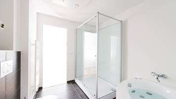 Une salle de bain moderne avec une douche à parois de verre, une baignoire sur pieds et des toilettes.