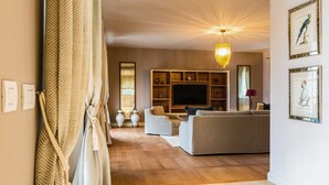 A spacious living room with a large TV, comfortable seating, and a decorative chandelier. - Villa Palazzo di Zara with Pool (Vabriga)