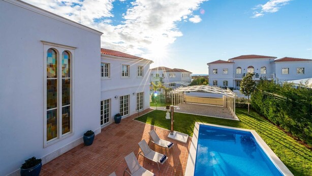 A residential area with a swimming pool, white houses, and a clear sky. - Villa Palazzo di Zara with Pool (Vabriga)