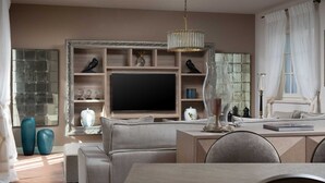 A modern living room with a large flat-screen TV, comfortable seating, and decorative items. - Villa Palazzo di Giulia with Pool (Vabriga)