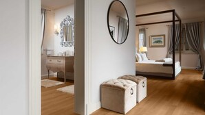 A bedroom with a four-poster bed, a large mirror, and a bedside table with a lamp. - Villa Palazzo di Giulia with Pool (Vabriga)