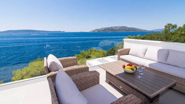 A terrace with wicker furniture, a white sofa, and a table with fruit and wine glasses. - Beachfront Villa Sea Touch (Okrug Donji)