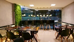 A conference room with a glass partition, modern chairs, and a green wall.