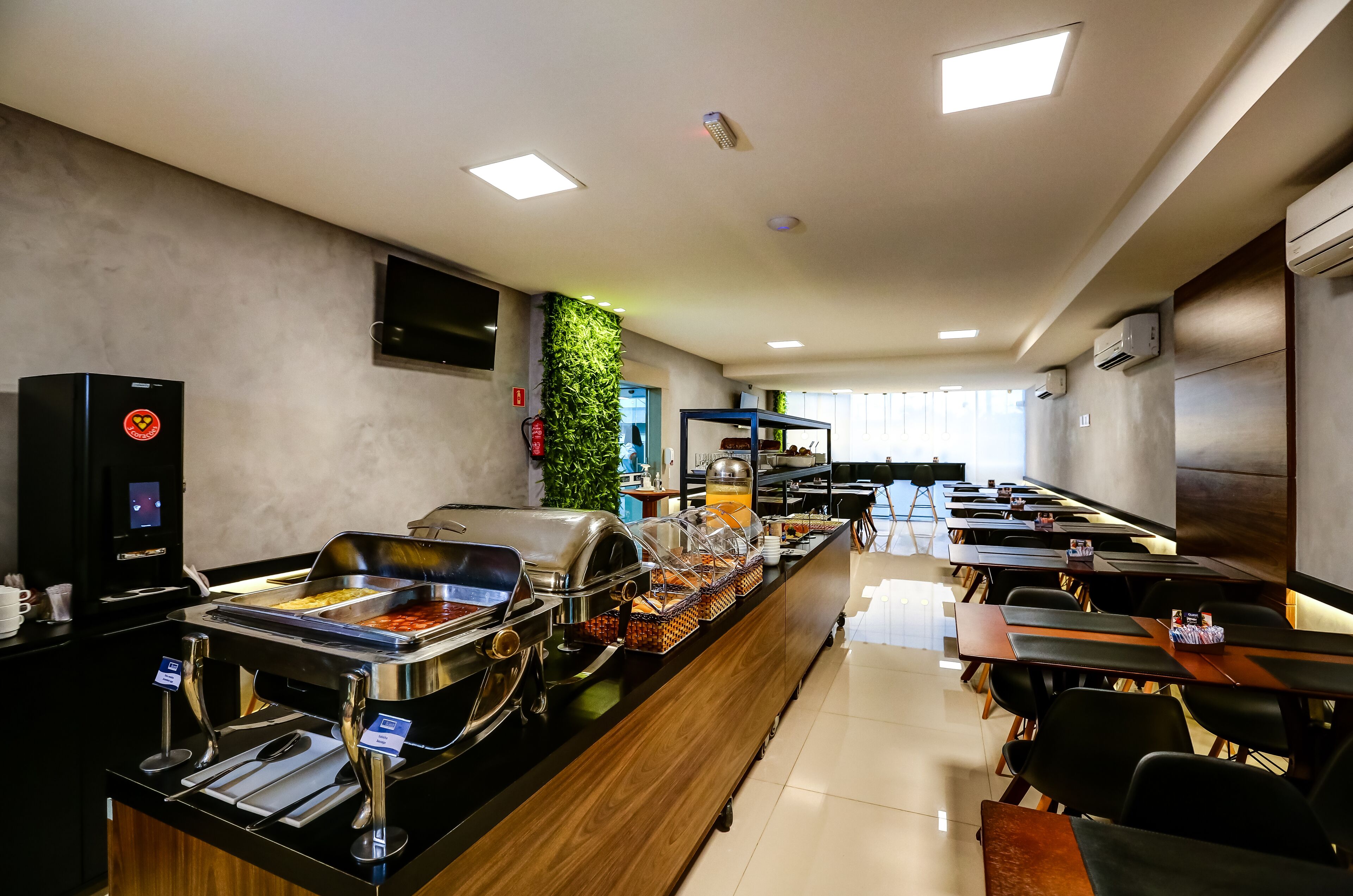 A buffet area with various food stations, a coffee machine, and a seating area with tables and chairs.