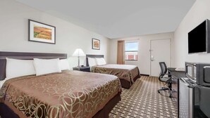 A hotel room with two beds, a desk with a computer, a TV, and a window with curtains. - Knights Inn Slaton (Slaton)