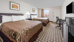A hotel room with two beds, a desk with a TV, a window, and artwork on the walls. - Knights Inn Slaton (Slaton)
