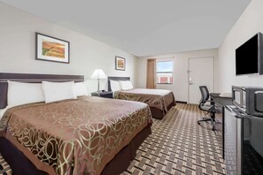A hotel room with two beds, a desk with a TV, a window, and artwork on the walls. - Knights Inn Slaton (Slaton)