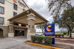 A hotel entrance with a covered walkway, a sign for Comfort Suites, and a parking area. - Comfort Suites Houston Near Medical Center- NRG Stadium (Houston)