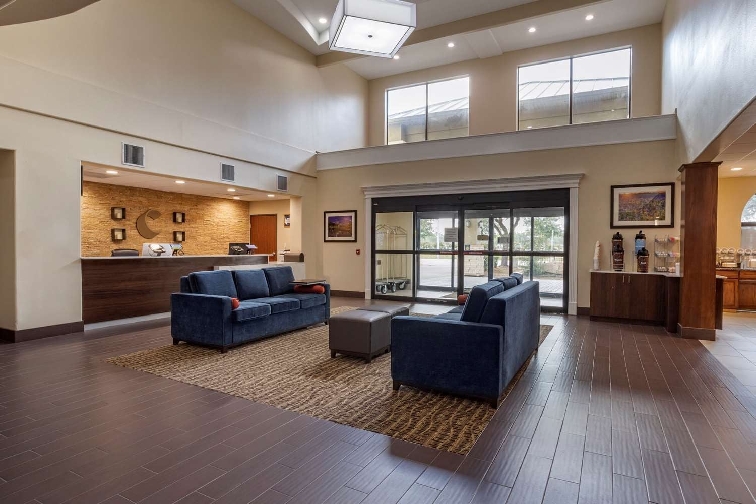 A spacious lobby with a reception desk, seating area, and large windows.