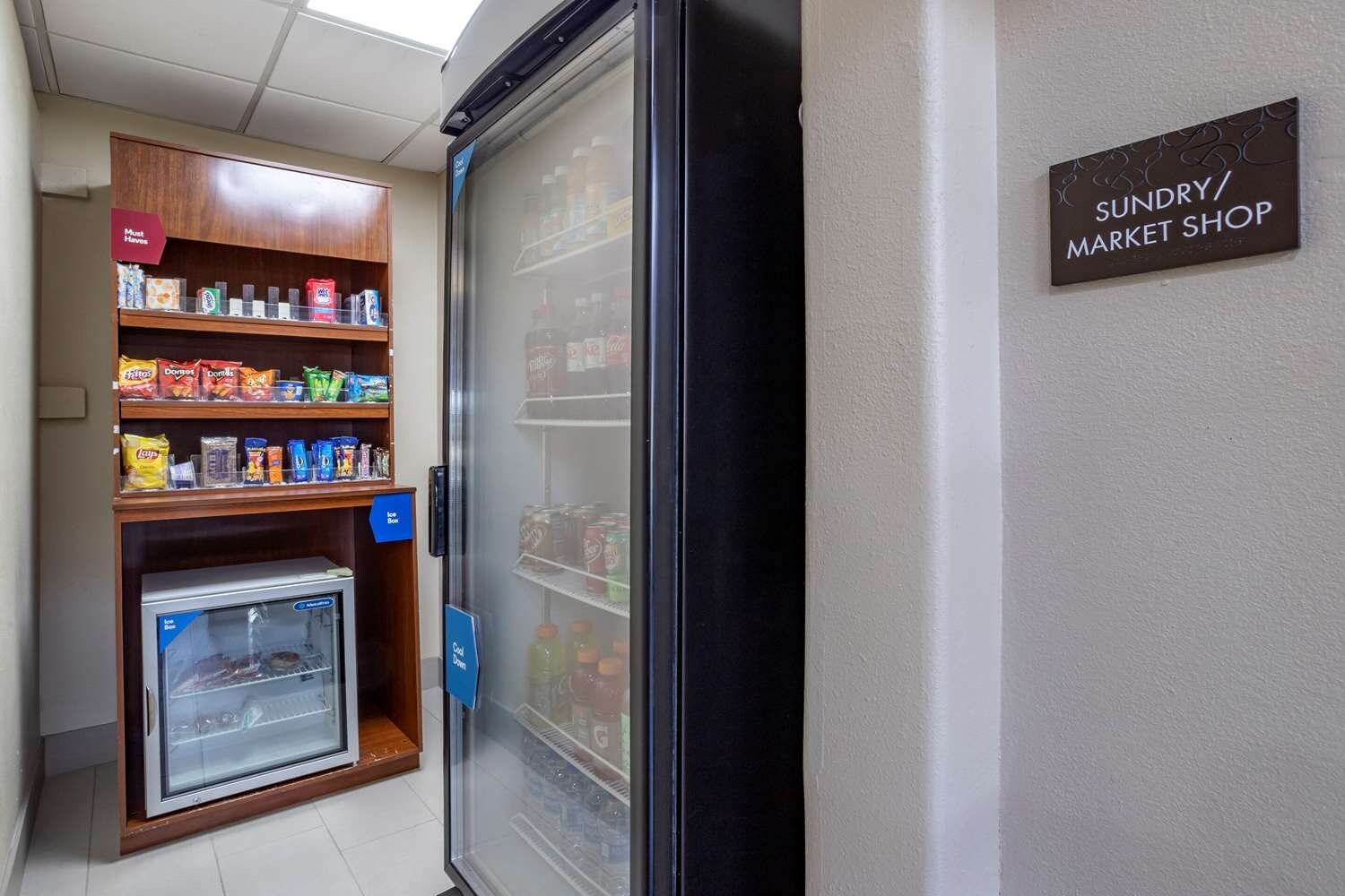 Un refrigerador exhibe productos, con un cartel que indica una tienda de conveniencia.