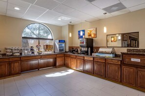 A hotel kitchen with a large window, a coffee station, and a trash bin. - Comfort Suites Houston Near Medical Center- NRG Stadium (Houston)