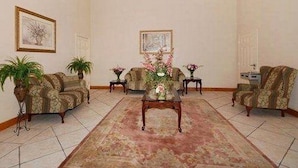 A formal sitting room with a central coffee table, two sofas, and a patterned rug. - Red Roof Inn & Suites Houston Humble/iah Airport (Humble)