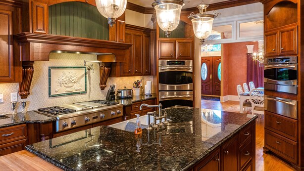 A spacious kitchen with granite countertops, stainless steel appliances, and wooden cabinetry. - Large House w/ Private pool - perfect for Golfing Groups 12 beds in 6 bedrooms (Pinehurst)
