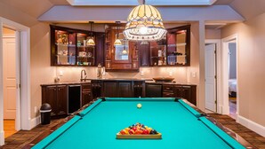 A pool table in a room with wooden cabinets and a chandelier. - Large House w/ Private pool - perfect for Golfing Groups 12 beds in 6 bedrooms (Pinehurst)