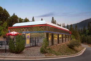 A building with a white roof and a Coca-Cola branded umbrella. - Travelodge by Wyndham Dunsmuir (Dunsmuir)