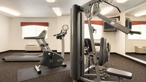 A gym with cardio machines, weightlifting equipment, and a mirrored wall. - Travelodge by Wyndham Dunsmuir (Dunsmuir)