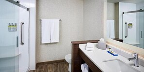 A modern bathroom with a shower, toilet, and sink. - Holiday Inn Express Canton Potsdam (Canton)