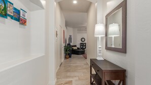 A hallway with a wooden console table, a mirror, and framed pictures on the wall. - Ahwatukee/Foothills-Golfer's Paradise! Desert Vacation Retreat/Gated Community! (Phoenix)