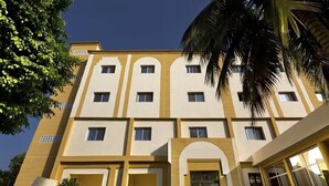 Un hotel de varios pisos con una fachada simétrica, ventanas amplias y una entrada central con dosel.