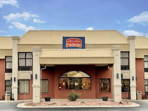 A FairBridge Inn & Suites building with a prominent sign, large windows, and a landscaped entrance area. - Fairbridge Inn Suites Fort Wayne (Fort Wayne)