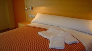 A hotel room with a bed, a nightstand, and a lamp. - Esperanza del Mar Apartments (Sanxenxo)