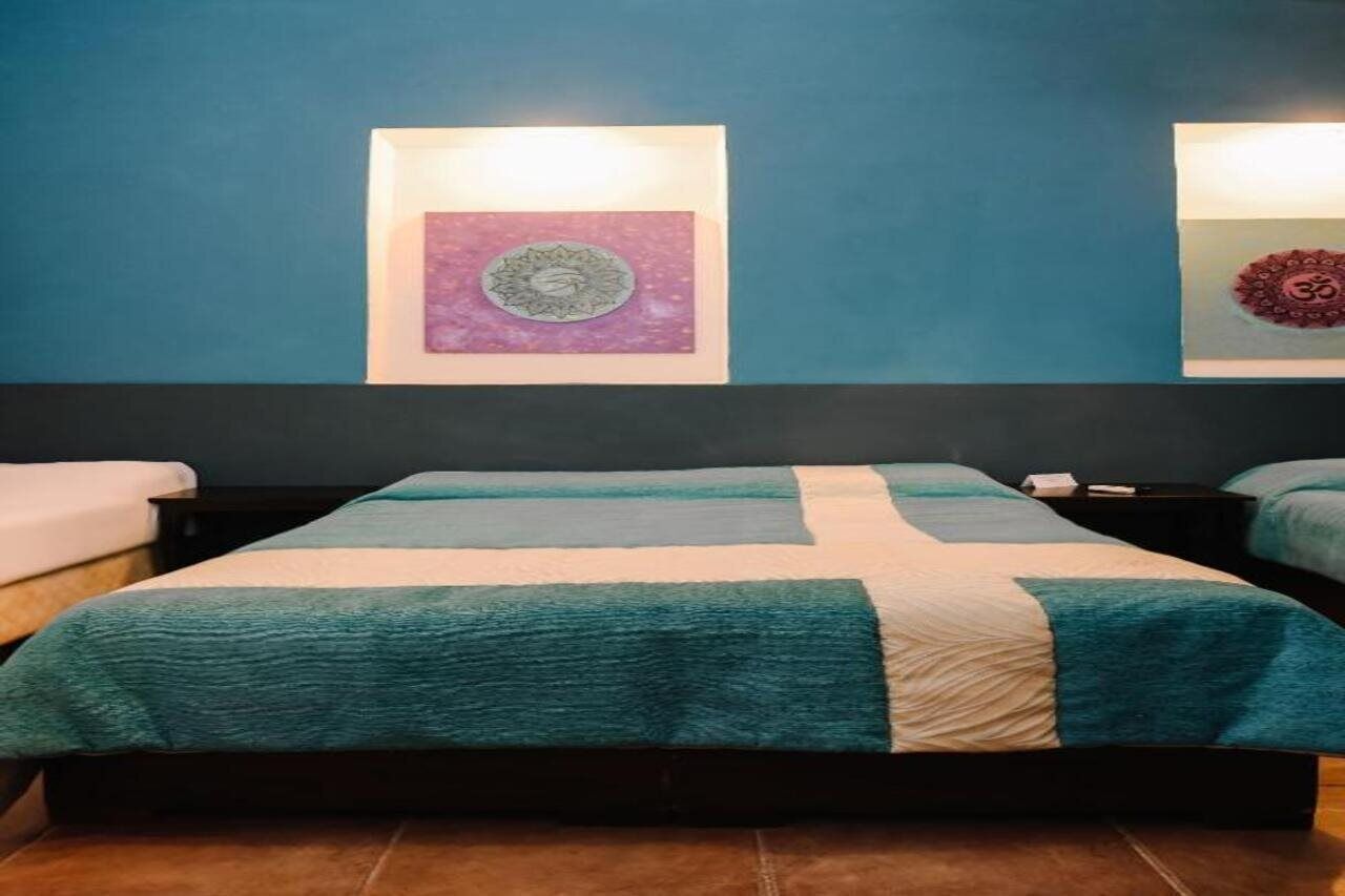 A hotel room with a large bed, two bedside tables, and a wall-mounted artwork.