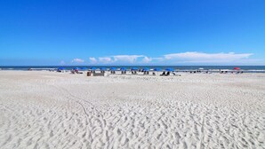 Ein Strand mit weißem Sand und blauem Himmel.