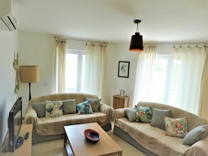 A living room with two sofas, a coffee table, a TV, and a lamp.