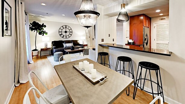 Una cucina moderna con un'isola centrale, sgabelli da bar e illuminazione a sospensione.