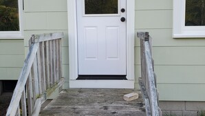 A white door with a small window above it, a wooden staircase leading up to the door, and a small light fixture above the door. - Family Getaway, Minutes away from Leland, Lake Leelanau, Suttons Bay (Lake Leelanau)