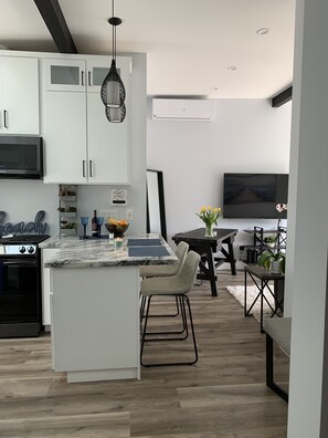 Enjoy meals in the kitchen with a spacious island and dining area featuring a large flat-screen TV.