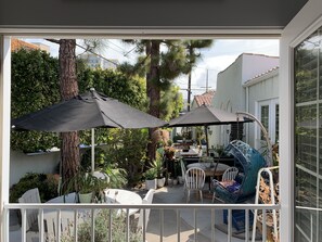 Enjoy dining or socializing in this serene outdoor patio area with a round table and comfortable seating.