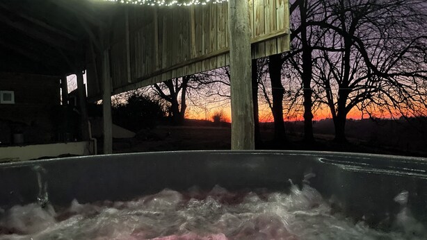 A hot tub area with a wooden structure overhead and a sunset view. - Spacious gite with large heated private swimming pool and new hot tub. (Salerm)