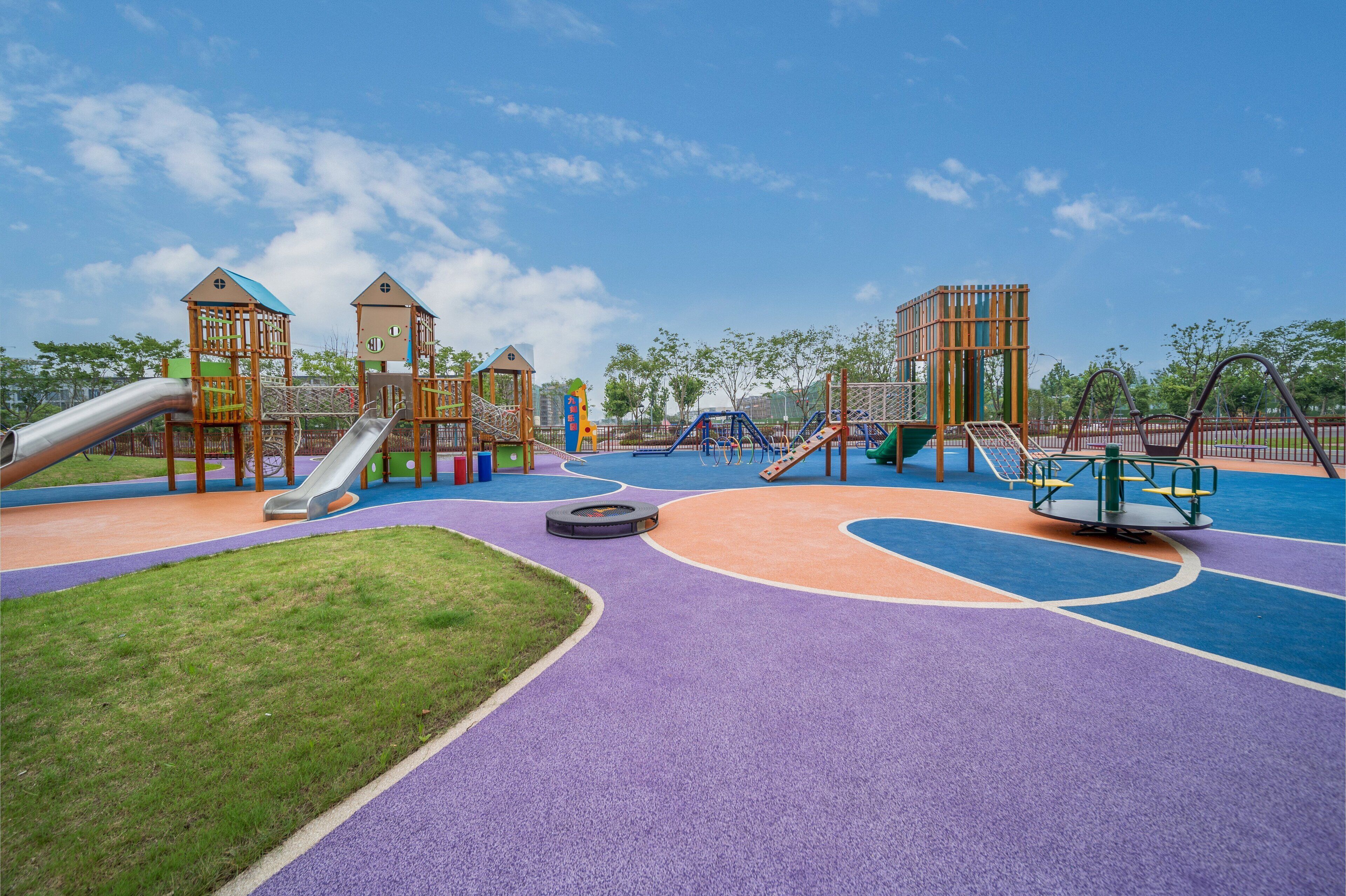 A playground with slides, climbing structures, and a circular play area.