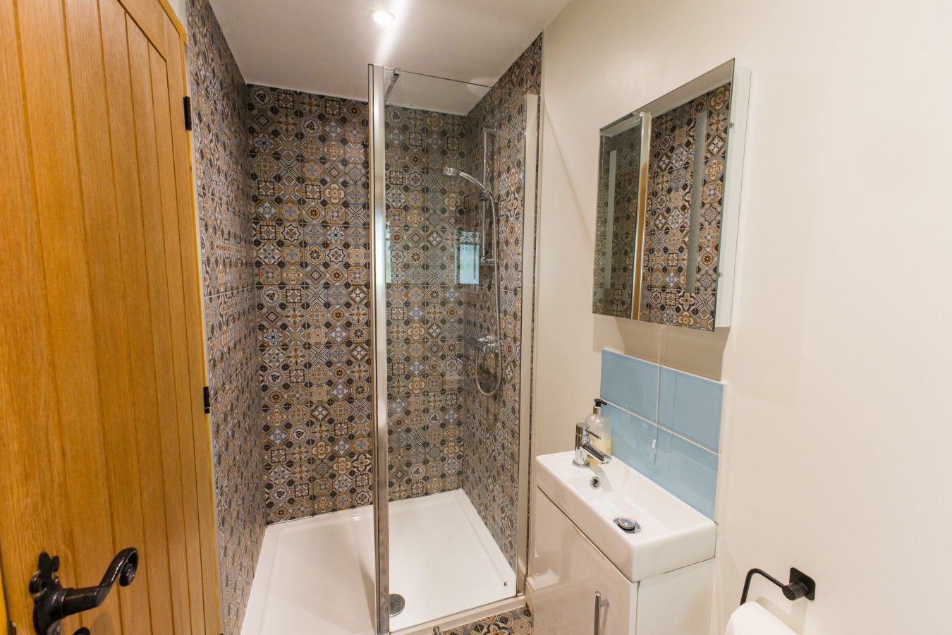 Ein Badezimmer mit Dusche, Waschbecken und Spiegel.